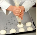 Перекладываем тесто в кондитерский мешок и выкладываем в виде круглых лепешек в 6 см. диаметром на застеленный пергаментом противень. Ставим противень в предварительно разогретую духовку на 15 минут. Выпеченные заготовки остужаем.	