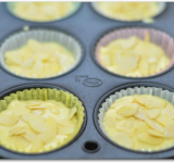 На 2/3 части наполняем формочки тестом, посыпаем миндальными лепестками и слегка вдавливаем их в тесто. Ставим форму в предварительно разогретую духовку на 25 минут.