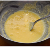 Ставим разогреваться духовку. Противень смазываем сливочным маслом и помещаем в холодильник. Затем снова смазываем противень сливочным масло, и снова остужаем, чтобы получился двойной слой масла. В миске взбиваем масло с сахарной пудры до воздушной консистенции. Добавляем в массу эссенцию и яйцо и хорошо взбиваем.	