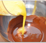 В какао вливаем масляную массу и ванильную эссенцию, все хорошо перемешиваем миксером.