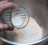 В большую миску насыпьте муку с солью, понемногу добавляя молоко, замешивайте тесто (около 2-3 минут).