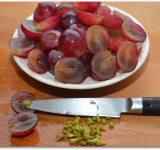 Виноградинки разрезаем пополам и извлекаем ножом косточки. Отдельно складываем виноград.