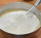 Теперь добавьте в тесто бананы и йогурт, снова перемешайте. Смешайте муку с разрыхлителем и аккуратно добавьте ее в будущее тесто. Теперь замесите, чтобы тесто получилось не густым.