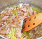 Мелкими полосками нарезаем бекон. В кастрюле нагреваем оливковое масло, добавляем бекон. Все обжариваем пару минут на среднем огне, пока бекон слегка не зажарится. В вегетарианском варианте обходятся без бекона.