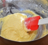 Постепенно в несколько этапов добавляем сахарную пудру, аккуратно перемешивая массу силиконовой лопаткой движениями сверху вниз.