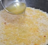 Снижаем огонь и начинаем постепенно добавлять бульон при постоянном помешивании. По мере выпаривания, добавляем новые порции бульона. Если бульон кончился, а рис не приготовился, добавляем просто кипяченую воду. Тушим таким образом рис примерно 20 минут.