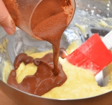 Какао разводим в воде, добавляем ванильную эссенцию и вмешиваем в крем. Хорошо взбиваем массу.