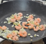 На сковороде растапливаем пол чайной ложки масла, обжариваем лук и креветки буквально пару минут, убираем их в сторону.