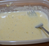 Готовим кляр, для этого перемешиваем кукурузную муку с яйцами. Постепенно при постоянном помешивании добавляем молоко, пока кляр не станет консистенции среднегустой сметаны. Солим, перчим кляр и добавляем любые приправы для курицы.