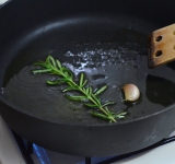 Масло выливаем на максимально разогретую сковороду, кладем в него неочищенный зубчик чеснока и веточку розмарина. Вынимаем их через 30 секунд.