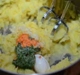 Сливаем воду с готового картофеля. Миксером взбиваем картофель в пюре, добавляем сыр Филадельфия, давленый чеснок и сливочное масло, можно составное (с петрушкой и красным перцем, например).