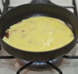 Заливаем грибы с ветчиной яйцами. Сверху натираем сыр.