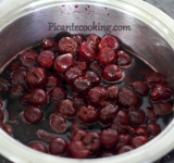 Приступаем к приготовлению вишневого слоя, для этого вишни с соком и сахаром помещаем в небольшой сотейник. Ставим емкость на малый огонь и варим при постоянном помешивании 2-3 минуты.