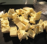 Все ингредиенты для теста должны быть холодными, поэтому предварительно ставим их на полчаса в холодильник. Масло нарезаем на крупные кусочки.