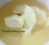 В отдельной емкости взбиваем до однородности сгущенное молоко и сыр.	