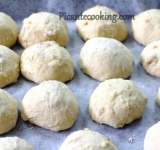 Разделяем тесто на 15-20 частей, формируем из каждого кусочка круглую булочку и выкладываем на застеленный пергаментной бумагой противень. Расстояние между булочками должно быть в 3-4 см. Накрываем противень влажным полотенцем и оставляем на час.