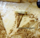 Плотно сворачиваем каждый треугольник в рожок. Выкладываем рожки на застеленный пергаментом противень и помещаем в предварительно разогретую духовку.	