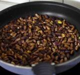 Подсушиваем фисташки на сковороде до румяности. Остужаем орехи полностью.	