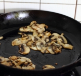 Для начала нарежьте грибы на пластинки и измельчите зеленый лук. Разогрейте сухую сковородку и обжарьте на ней семечки кунжута, пока они не приобретут золотистый оттенок. Разогрейте сковородку с 2 столовыми ложками растительного масла и пожарьте на нем грибы до готовности, время от времени помешивая. Когда грибы будут готовы- переложите их в мисочку.