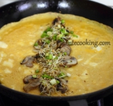 Разогрейте сковородку, в которой жарились грибы, с 1 столовой ложкой растительного масла. В отдельной миске хорошенько взбейте яйца с соевым соусом. Вылейте яичную смесь в сковородку, и когда омлет немного схватится- выложите в серединку грибы и ростки, а затем заверните края омлета внутрь.