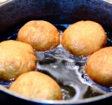 Во фритюрнице или глубокой сковороде нагреваем растительное масло до раскаленного состояния. Огонь снижаем до среднего и аккуратно опускаем пончики по одному. Обжариваем их небольшими порциями до равномерного румянца.