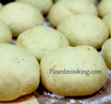 Подошедшее тесто разминаем и скатываем 15 небольших шариков. Выкладываем их на просыпанную мукой рабочую поверхность на расстоянии 3 см. Накрываем их кухонным полотенцем и оставляем на полчаса.