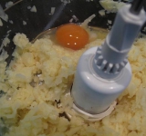 Для начала очистите картошку и лук. Если у вас есть кухонный комбайн, то это значительно упрощает процесс приготовления! Просто поместите все ингредиенты в чашу и измельчите до однородности. Но можно готовить традиционно: натереть картофель и лук на мелкой терке, а затем в миске смешать тертые овощи, яйцо и муку, соль и перец.