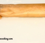 Из пергамента вырезаем отрезок в три ширины рулета. Рулет, очень осторожно, оставляя сверху около 0,5 см свободными, заворачиваем в бумагу, так, чтобы стык бумаги был под рулетом. Должен получиться не тугой сверток. Перекладываем рулет на сухой противень, и ставим в предварительно разогретую духовку на 40-45 минут.