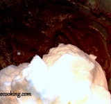 Отделяем белки от желтков. Взбиваем белки в густую пену. Желтки по одному вводим в шоколадную массу, перемешивая до однородности. В отдельную емкость просеиваем сухие ингредиенты, перемешиваем и постепенно добавляем в шоколадно-масляную смесь. Перемешиваем до однородности. Добавляем 2 ст. ложки белков, вымешиваем массу силиконовой лопаткой. Затем добавляем оставшиеся белки и вновь перемешиваем.