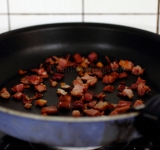 Для начала мелко нарежьте бекон (можно заменить копченной колбасой) и натрите сыр на терке. Разогрейте духовку до 180 градусов. Разогрейте сухую сковородку и обжарьте на ней бекон до хруста. Выложите на полотенце, чтобы стек жир. Тертый сыр смешайте с крахмалом.