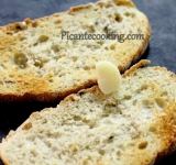 Кусочки хлеба подсушиваем до румяности в тостере и со всех сторон натираем чесноком. Периодически опускаем зубчик в соль, так натирать будет проще.