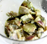 Готовые артишоки перекладываем в миску и добавляем все ингредиенты для заправки, кроме трав, перемешиваем и оставляем пропитаться на 5-10 минут.