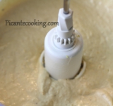 Готовый нут отцедите от жидкости и поместите в блендер вместе с чесноком, маслом, тахини, цедрой, специями и йогуртом. Тщательно все измельчите до однородной массы. Добавьте лимонный сок и, продолжая взбивать, тонкой струйкой вливайте воду. Может понадобится чуть меньше или чуть больше воды, для желаемой консистенции.