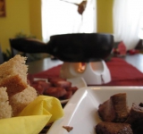 Подавать фондю хорошо на настольном подогревателе, мясо, колбасу и хлеб выкладываем вокруг на тарелках.	