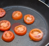 Порежьте помидоры на ломтики и обжарьте на сковороде на умеренно сильном огне до легкой поджаристой корочки.	