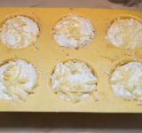 Выложите полученную смесь в формочки для суфле (не до конца, суфле поднимется в духовке). Сверху посыпьте оставшимся тертым сыром.	