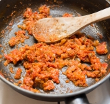 Лук порежьте и обжарьте на сковороде на умеренно среднем огне в течении 3-4 минут. Добавьте томатную пасту и готовьте еще 1 минуту.	