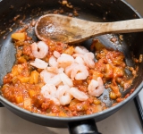 Добавьте креветки, посолите, поперчите и перемешайте. Готовьте около 2 минут.	