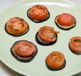 Помидоры выложите на баклажаны. Посолите сверху слегка.	