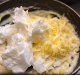 Смешайте ¼ часть взбитых белков со всем тертым сыром (оставьте около 2 ст.л. тертого сыра на потом) и приготовленным соусом бешамель. Перемешайте аккуратно смесь.	