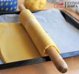 Теперь раскатайте из теста пласт толщиной примерно 8 мм. Разогрейте духовку и выстелите противень пергаментом. Аккуратно накрутите тесто на скалку и перенесите его на противень. Запекайте до легкого зарумянивания, минут 8-15, зависит от духовки. 
Точно так же испеките второй корж.	