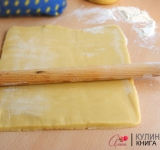 Для начала холодное масло нарежьте на небольшие кусочки и взбейте при помощи миксера или комбайна. Добавьте соль, сахар и ванильный сахар. Одно яйцо и один желток немного взбейте в отдельной миске и вливайте понемногу. 
 
Соду (на кончике ножа) погасите уксусом и введите в тесто. Просейте в тесто муку и хорошенько замесите тесто. Поставьте в холодильник минут на 30. 
 
Охлажденное тесто разделите на 2 части. Если у вас большой противень, то тесто можно не делить на 2 части, а просто испечь 1 большой корж и потом разрезать.	