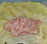 Приготовьте фарш. Для этого добавьте в него измельченный лук, рис, соль и черный молотый перец. Можно добавить и любые другие специи, но мне больше нравится натуральный вкус.
Теперь заворачиваем голубцы. Тут кто на что горазд. Я заворачиваю конвертиками, чтобы фарш не выпал при готовке. Можно свернуть и трубочками, и как вам удобно.