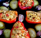 Обрызните картошку оливковым маслом. Перец разрежьте на половинки вдоль, очистите от семян, а затем наполните каждую половинку перца готовой начинкой. Разделите чеснок на зубчики, не очищая от кожуры.
Жароупорное блюдо смажьте тонким слоем оливкового масла, выложите на него перцы, а между ними по две половинки картошки. Произвольно разложите по форме чеснок.