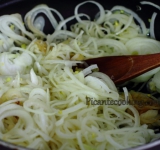 Лук очистите и нарежьте кольцами. Хорошенько разогрейте сковородку, добавьте в нее растительное и сливочное масло и когда сливочное масло перестанет пениться, добавьте лук. Добавьте соль и сахар, хорошенько перемешайте и тушите, иногда помешивая, пока лук полностью не размякнет и не приобретет насыщенный золотистый цвет. Это займет минут 25-30.	