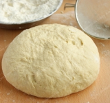 Для начала сливочное масло и сахар выложите в миску и взбейте при помощи миксера. Продолжая взбивать, добавьте яйца, а через несколько минут введите молоко, не переставая взбивать на средней скорости. Аккуратно перемешайте при помощи венчика.  
 
Отмерьте примерно 150 грамм муки, добавьте к ней соду, хорошенько перемешайте, а затем просейте в яичную смесь. Тщательно перемешайте, а потом, продолжая помешивать, постепенно введите оставшуюся муку (лучше всего ее тоже просеивать, чтобы не было комочков). Когда тесто станет достаточно густым, выложите его на стол. Тщательно замесите его руками, пока тесто не станет плотным и перестанет липнуть к рукам. Оставьте его полежать на столе минут на 30.	