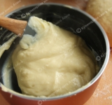 Теперь приготовим крем. Яйца и крахмал тщательно перемешайте венчиком так, чтобы не было комочков. Слегка подогрейте молоко и маленькую часть влейте в желтковую смесь, хорошо перемешайте. Полученную смесь вылейте в подогретое молоко. Варите на среднем огне в антипригарной посуде до момента загустения, постоянно помешивая. Если нет антипригарной посуды, можно использовать водяную баню. 
Если у вас появятся в креме комочки, взбейте его погруженным блендером. 
 
Оставьте крем остывать до комнатной температуры.	