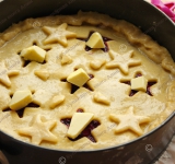 Вырезанные фигурки разложите на пирог. Верх пирога смажьте белком и в каждое отверстие в верхушке положите по кусочку масла (тогда начинка не вытечет во время приготовления).