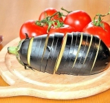 .Разогрейте духовку. Смажьте форму для запекания маслом, выложите в нее баклажан и слегка раскройте надрезы. Смажьте надрезы в баклажане растительным маслом, а потом вложите туда немного пасты из брынзы и кусочек помидора. Сверху можно присыпать тертым сыром пармезан…	