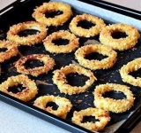 Готовые кольца выложите на противень и выпекайте каждую сторону до золотистой корочки по 8 минут в среднем. Когда лук готов, сразу посолите его, пока он еще горячий. Готово! Подавать эту вкуснятину лучше всего с каким-нибудь соусом. Приятного аппетита!